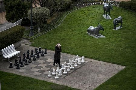 A member of the Iranian media walks on a chess board at the Beau Rivage Palace Hotel in Lausanne March 30, 2015. REUTERS/Brendan Smialowski/Pool