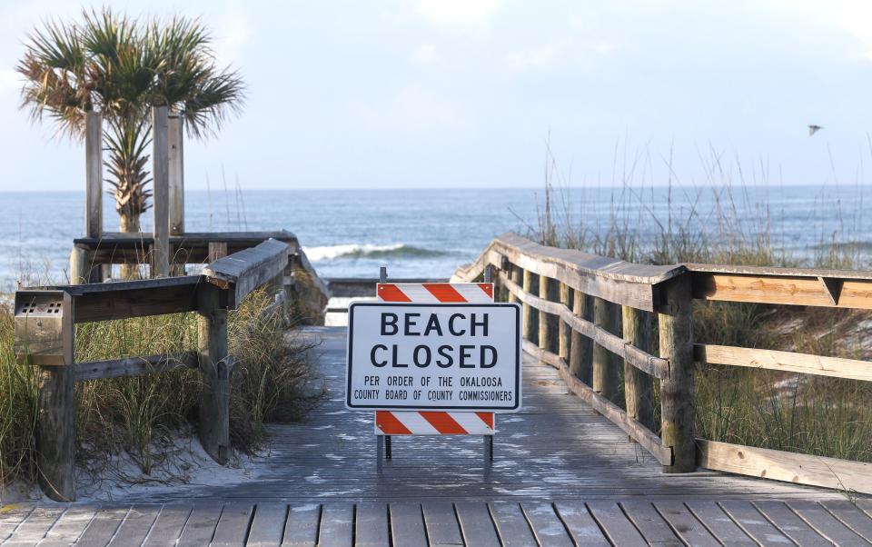 Signs block the paths to the beach at the Okaloosa Island, Florida, Boardwalk, Saturday, March 21, 2020, as beach closure orders are in effect for Walton and Okaloosa Counties in the Northwest Florida panhandle.