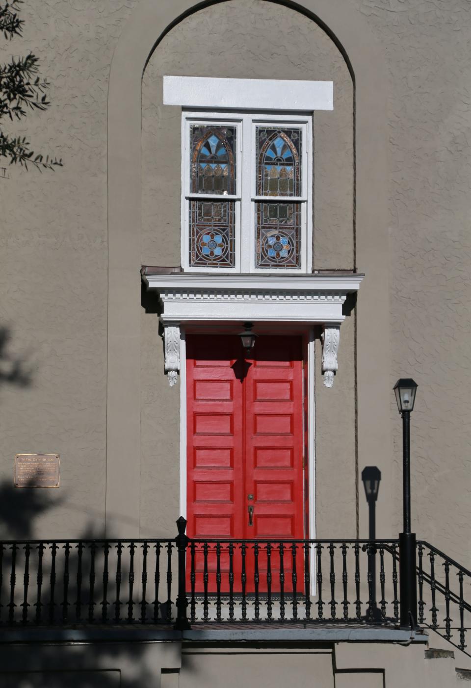 The bright red doors of First African Baptist Church can be seen under the stained glass windows of the historic church.