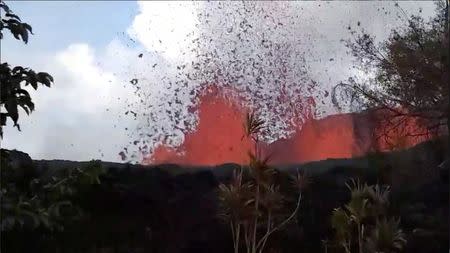 Lava is seen from a fissure appearing behind a resident's backyard in Puna, Hawaii, U.S. in this still frame taken from May 6, 2018 video obtained from social media. KEITH BROCK/Social Media via REUTERS