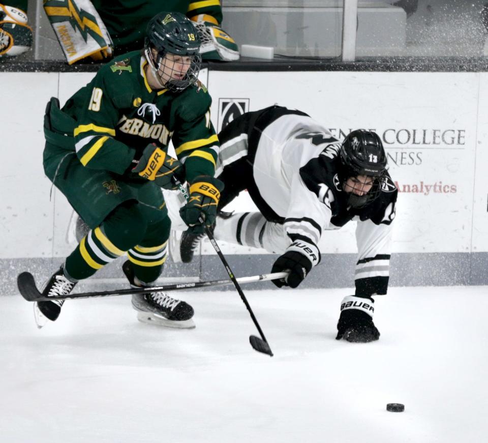 Providence College's Craig Needham reaches for the puck as he trips over UVM's Simon Jellus during the opening round of Hockey East playoffs last season.
