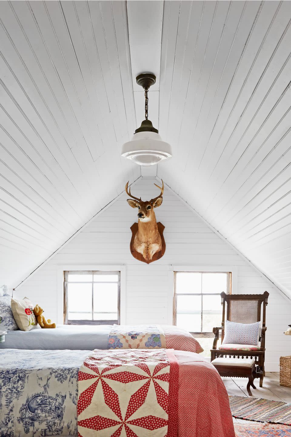 white attic bedroom with two twin beds covered in vintage inspired quilt bedding