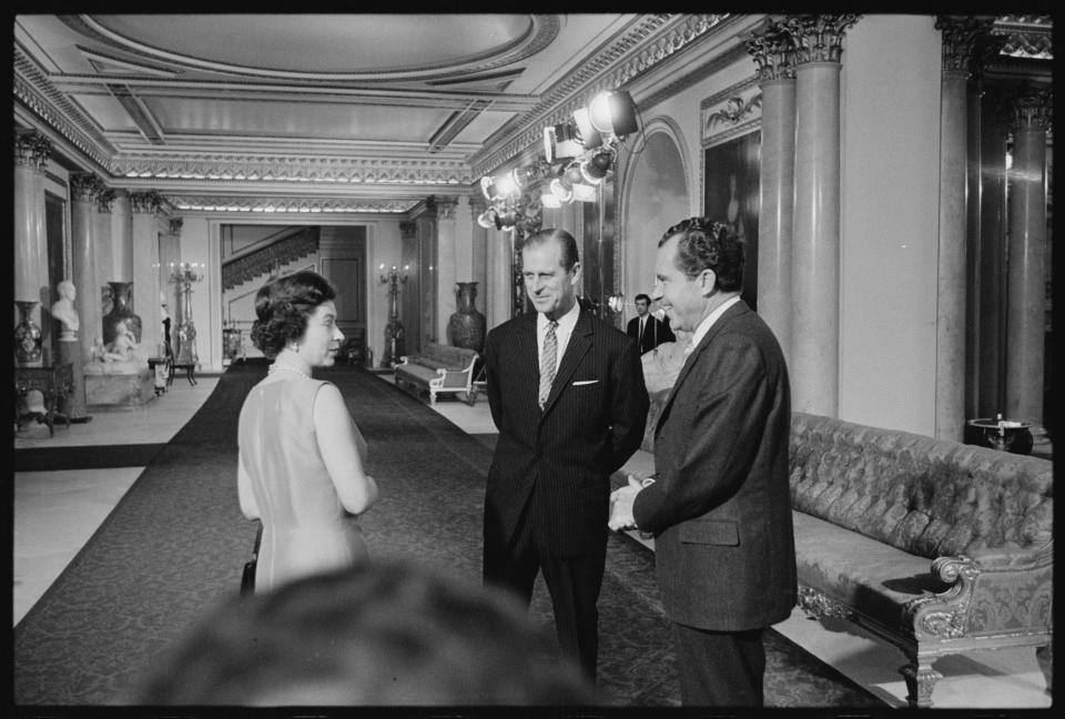 In this undated image provided by The Richard Nixon Library & Museum, Queen Elizabeth II and her husband Prince Philip talk with U.S. President Richard Nixon at Buckingham Palace in London. / Credit: The Richard Nixon Library & Museum via AP
