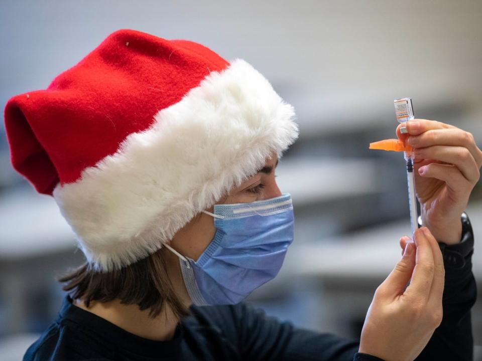 Medical student Morgyn McKerlie draws outs COVID-19 vaccine at a drive-through vaccine clinic at St. Lawrence College in Kingston, Ont., on Dec. 4, 2021. (Lars Hagberg/The Canadian Press - image credit)