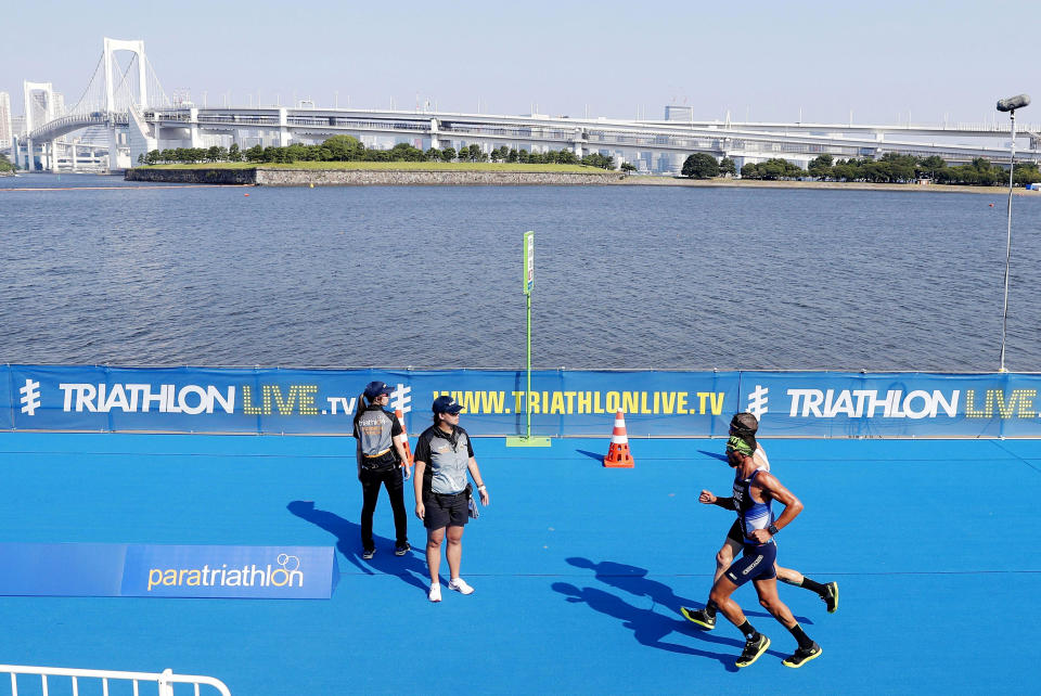 Competitors run in a paratriathlon test event for Tokyo 2020 in Tokyo, Saturday, Aug. 17, 2019. High bacteria levels forced the swimming portion of a triathlon test event for the Tokyo Paralympics to be cancelled on Saturday.(Takuya Inaba/Kyodo News via AP)