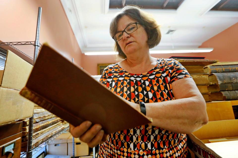 New Bedford Public Library Director, Olivia Melo looks at the 100-year overdue book. An Elementary Treatise on Electricity by James Clerk Maxwell was returned to the West Virginia University library one hundred years after it was taken out of the New Bedford Public library in 1903.