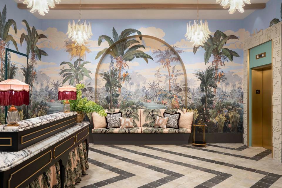 Tropical murals, a marble accented concierge desk, and fringed lamps welcome guests in the highly Instagrammable lobby designed by Ken Fulk.