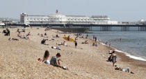 People on Brighton Beach in East Sussex, England as the UK continues in lockdown to help curb the spread of the coronavirus, Saturday May 9, 2020. (Gareth Fuller/PA via AP)