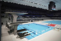 A diver demonstrates during a grand opening ceremony of Tokyo Aquatics Center Saturday, Oct. 24, 2020, in Tokyo. The Tokyo 2020 organizing committee held the grand opening ceremony Saturday at the aquatics center, planned to host Olympic artistic swimming, diving and swimming and Paralympics swimming events in 2021. (AP Photo/Eugene Hoshiko)