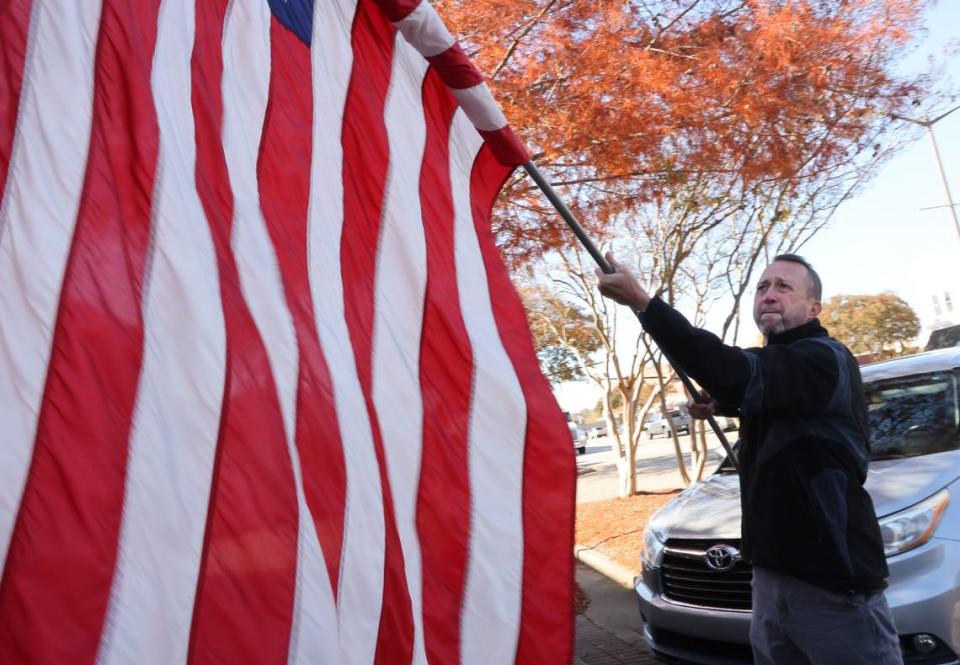 Clover mayor-elect Bo Legg rolls up an American flag he put out on Main Street for Veterans Day.