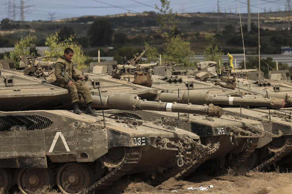 An Israeli soldier sits on top of a tank at a staging ground near the border with Gaza Strip, southern Israel, Friday, May 21, 2021. A cease-fire took effect early Friday after 11 days of heavy fighting between Israel and Gaza's militant Hamas rulers that was ignited by protests and clashes in Jerusalem. (AP Photo/Tsafrir Abayov)