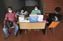 People receive a shot of the Sinovac's COVID-19 vaccine during a vaccination campaign at the Patriot Candrabhaga Stadium in Bekasi on the outskirts of Jakarta, Indonesia Friday, Nov. 26, 2021. Indonesia has significantly recovered from a mid-year spike in coronavirus cases and deaths that was one of the worst in the region, but with its vaccination drive stalling and holidays approaching, experts and officials warn the island nation could be set soon for another surge. (AP Photo/Achmad Ibrahim)