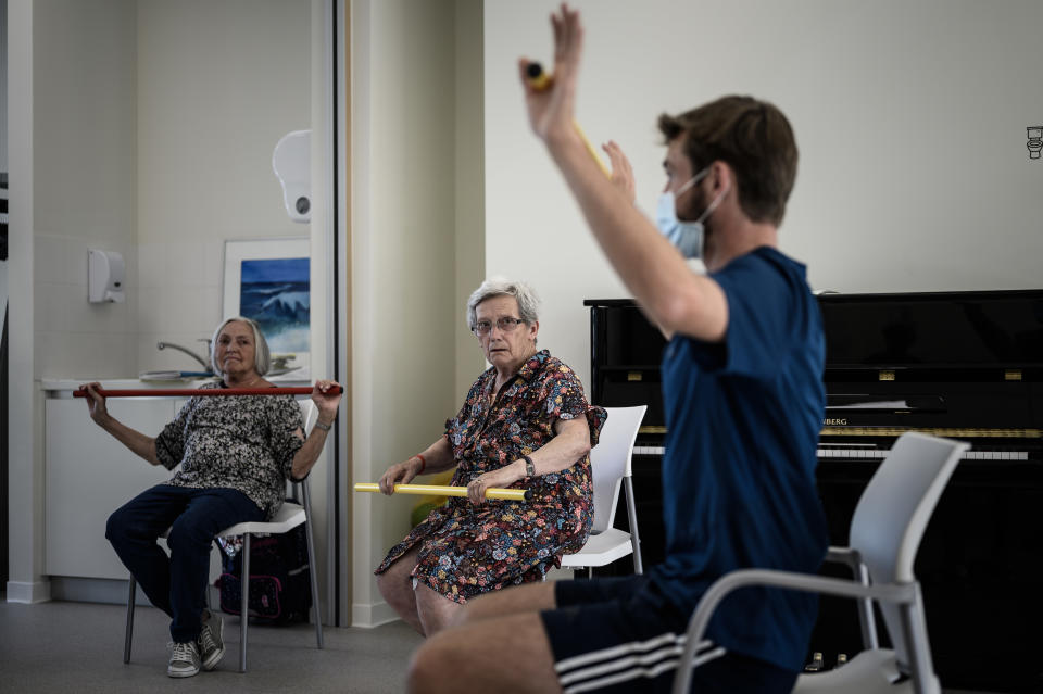 Un voluntario ayuda a los enfermos a realizar actividad física. (Foto: Philippe Lopez / AFP / Getty Images).