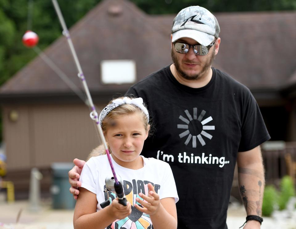 Amelia Zimmerman, 9, gets pointers from her father, Brandon, while fishing during Summerfest at Sippo Lake Park.