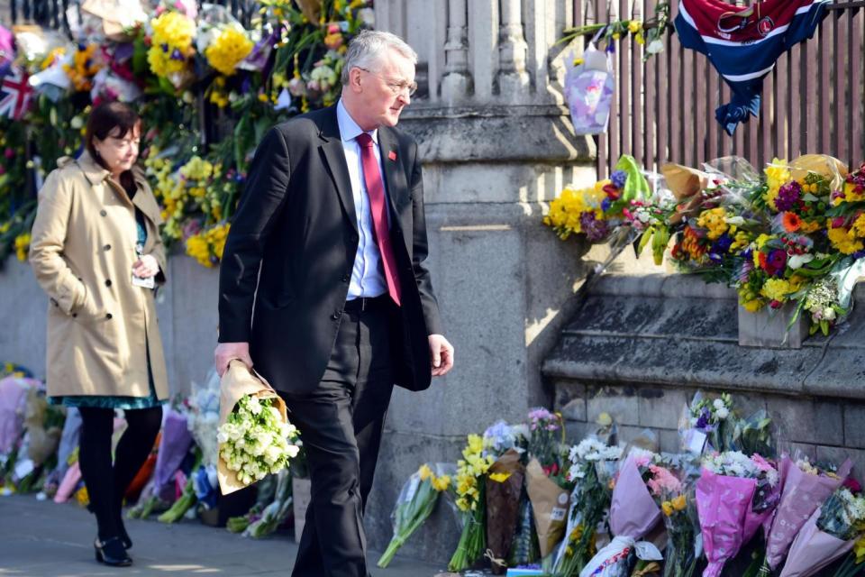 Touching tributes: Labour MP Hilary Benn passes floral tributes to the victims of the Westminster terrorist attack (Lauren Hurley/PA )