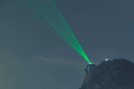 Anti-extradition bill protesters use laser beams as they form a human chain on top of the iconic Lion Rock, at Wong Tai Sin, during mid-autumn festival in Hong Kong