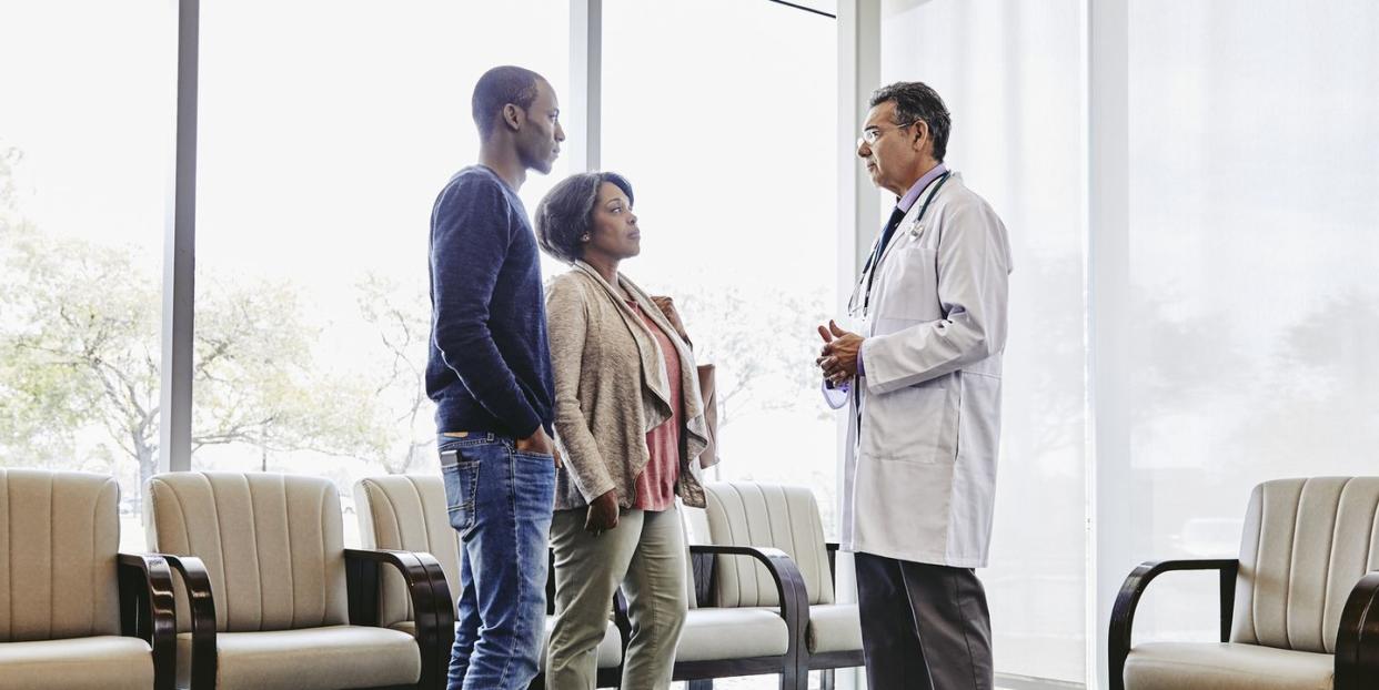 doctor talking to mother and son in hospital waiting room