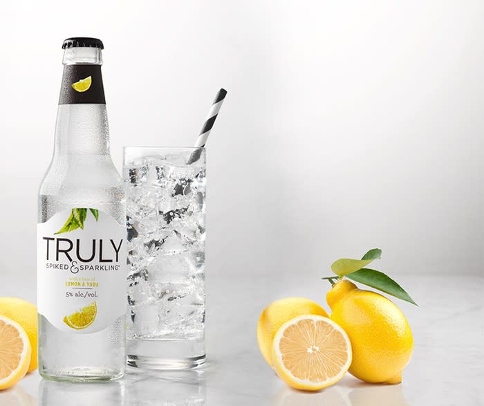 Bottle and glass of Truly hard seltzer with lemons