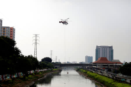 A helicopter collects water from Ciliwung river to be sprayed around protesters in Petamburan district, following the announcement of last month's election official results in Jakarta, Indonesia, May 22, 2019. REUTERS/Willy Kurniawan