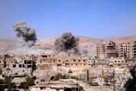 <p>Smokes rise after Assad Regime forces carried out airstrikes in Eastern Ghouta’s Douma town in Damascus, Syria on April 7, 2018. (Photo: Halil el-Abdullah/Anadolu Agency/Getty Images) </p>