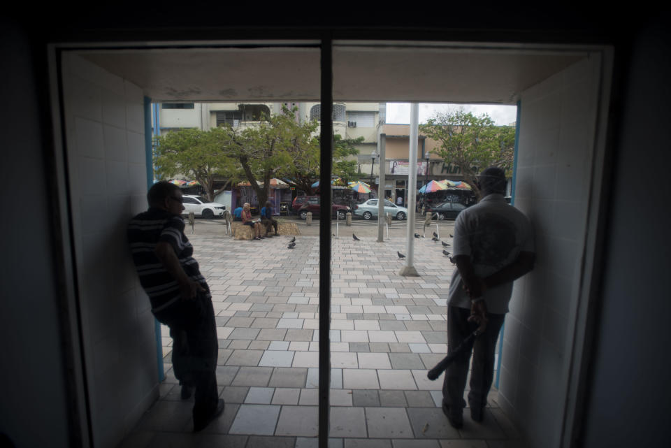 Residents stand inside the Plaza del Mercado in the Rio Piedras area of San Juan, Puerto Rico, Wednesday, April 17, 2019. New Census Bureau data shows that Puerto Rico lost nearly 4% of its population after Hurricane Maria - the greatest population drop in the recorded history of the island, according to one demographer. (AP Photo/Carlos Giusti)