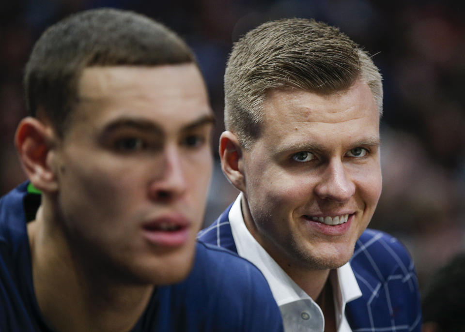 Dallas Mavericks forwards Kristaps Porzingis, right, and Dwight Powell watch from the bench during the first half of the team's NBA basketball game against the Portland Trail Blazers, Friday, Jan. 17, 2020, in Dallas. (AP Photo/Brandon Wade)