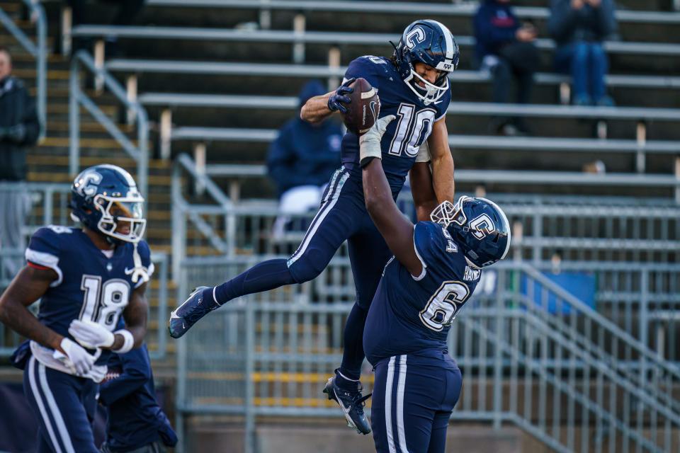 Nov 18, 2023; East Hartford, Connecticut, USA; UConn Huskies wide receiver Brett Buckman (10) is congratulated after his touchdown by offensive lineman Christian Haynes (64) against the Sacred Heart Pioneers in the second half at Rentschler Field at Pratt & Whitney Stadium. Mandatory Credit: David Butler II-USA TODAY Sports