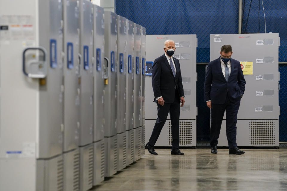 FILE - In this Feb. 19, 2021, file photo President Joe Biden walks by freezers used to hold the Pfizer COVID-19 vaccine as he tours a Pfizer manufacturing site with Albert Bourla, Pfizer CEO, in Portage, Mich. (AP Photo/Evan Vucci, File)