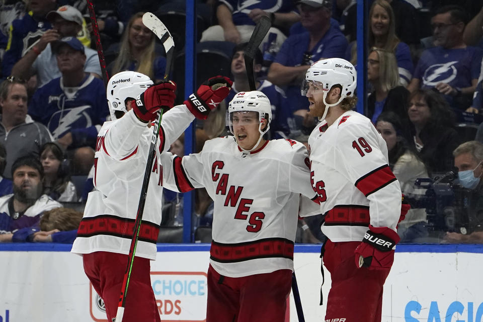 Carolina Hurricanes defenseman Dougie Hamilton (19) celebrates with teammates, including right wing Sebastian Aho (20) after scoring against the Tampa Bay Lightning during the second period in Game 4 of an NHL hockey Stanley Cup second-round playoff series Saturday, June 5, 2021, in Tampa, Fla. (AP Photo/Chris O'Meara)