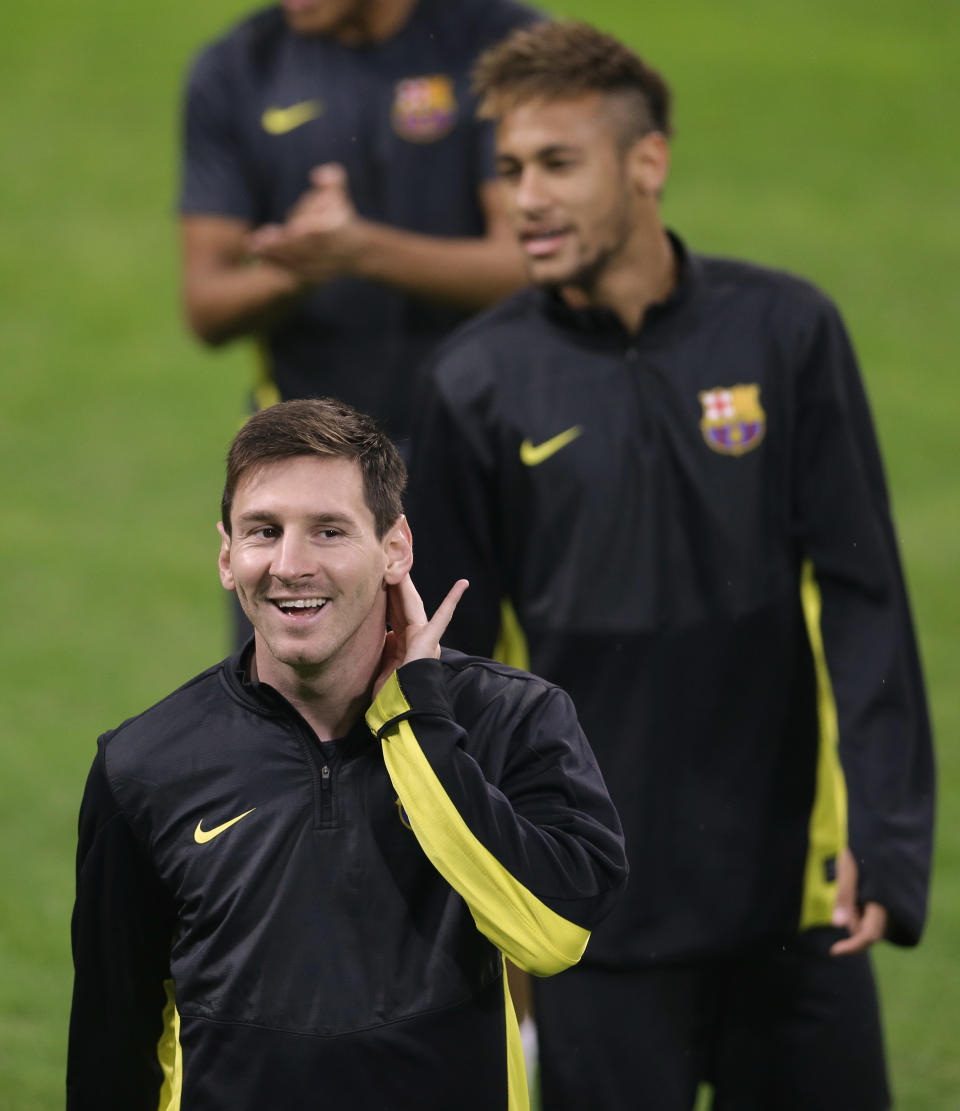 FILE - In this Oct. 21, 2013 file photo, Barcelona's Lionel Messi, of Argentina, foreground smiles as his teammate Barcelona's Neymar, of Brazil, is seen in the background during a training session at the San Siro stadium, in Milan, Italy. Brazilian fans hoping for a home-team win at this year's World Cup are hoping just as hard that archrival Argentina does not lift the trophy. (AP Photo/Luca Bruno, File)