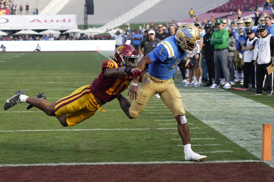 UCLA quarterback Dorian Thompson-Robinson, right, runs the ball in for a touchdown as Southern California linebacker Ralen Goforth defends during the first half of an NCAA college football game Saturday, Nov. 20, 2021, in Los Angeles. (AP Photo/Mark J. Terrill)