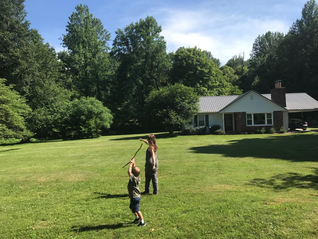 The author walking with her child in a yard