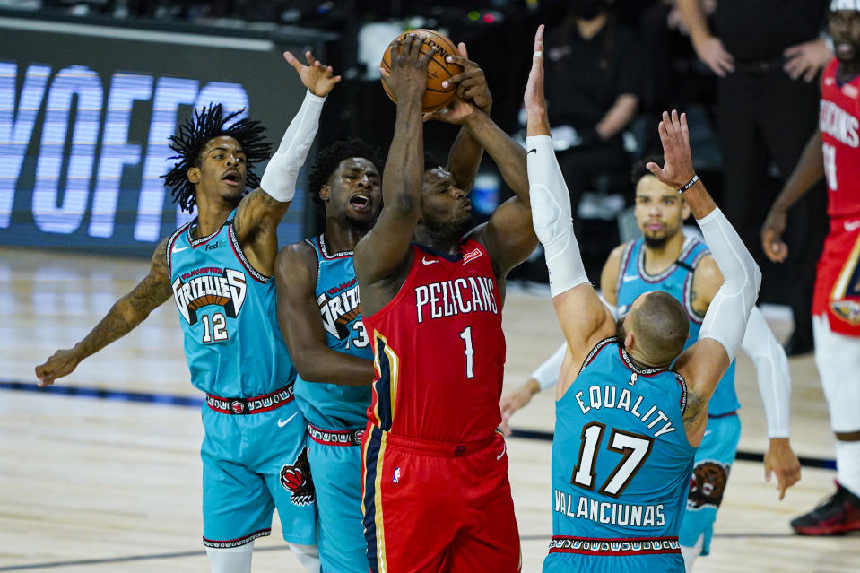 New Orleans Pelicans' Zion Williamson (1) is fouled by Memphis Grizzlies' Jaren Jackson Jr. (13) as he shoots over Grizzlies' Jonas Valanciunas (17) during the second half of an NBA basketball game Monday, Aug. 3, 2020 in Lake Buena Vista, Fla. (AP Photo/Ashley Landis, Pool)