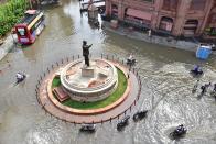 People pass through a waterlogged stretch after heavy rain, on July 19, 2020 in Amritsar, India. Moderate-to-heavy rain lashed several states in northern, eastern and coastal India on Sunday, but the monsoon activity continued to remain subdued in Delhi, which has recorded a 40 per cent rainfall deficiency despite an early onset of the seasonal weather system. (Photo By Sameer Sehgal/Hindustan Times via Getty Images)