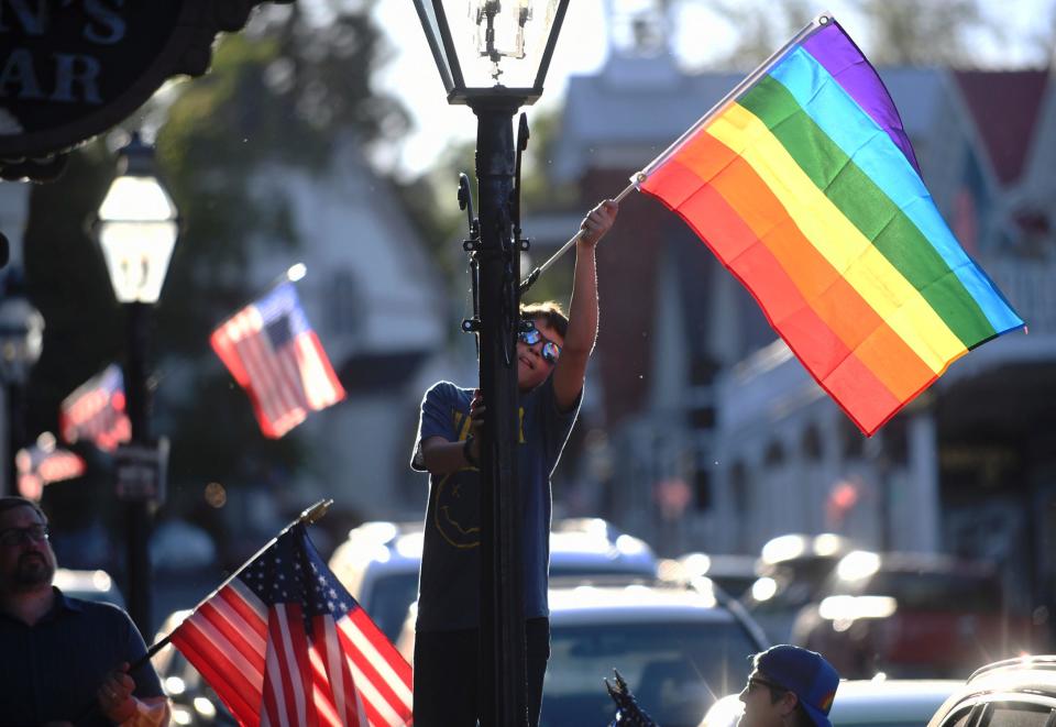 Families took part in the changing of the downtown Nevada City flags along Broad Street, Commercial Street, and Union Alley where the Pride flag is displayed for the month of June and Pride month, Tuesday, May 31, 2022.