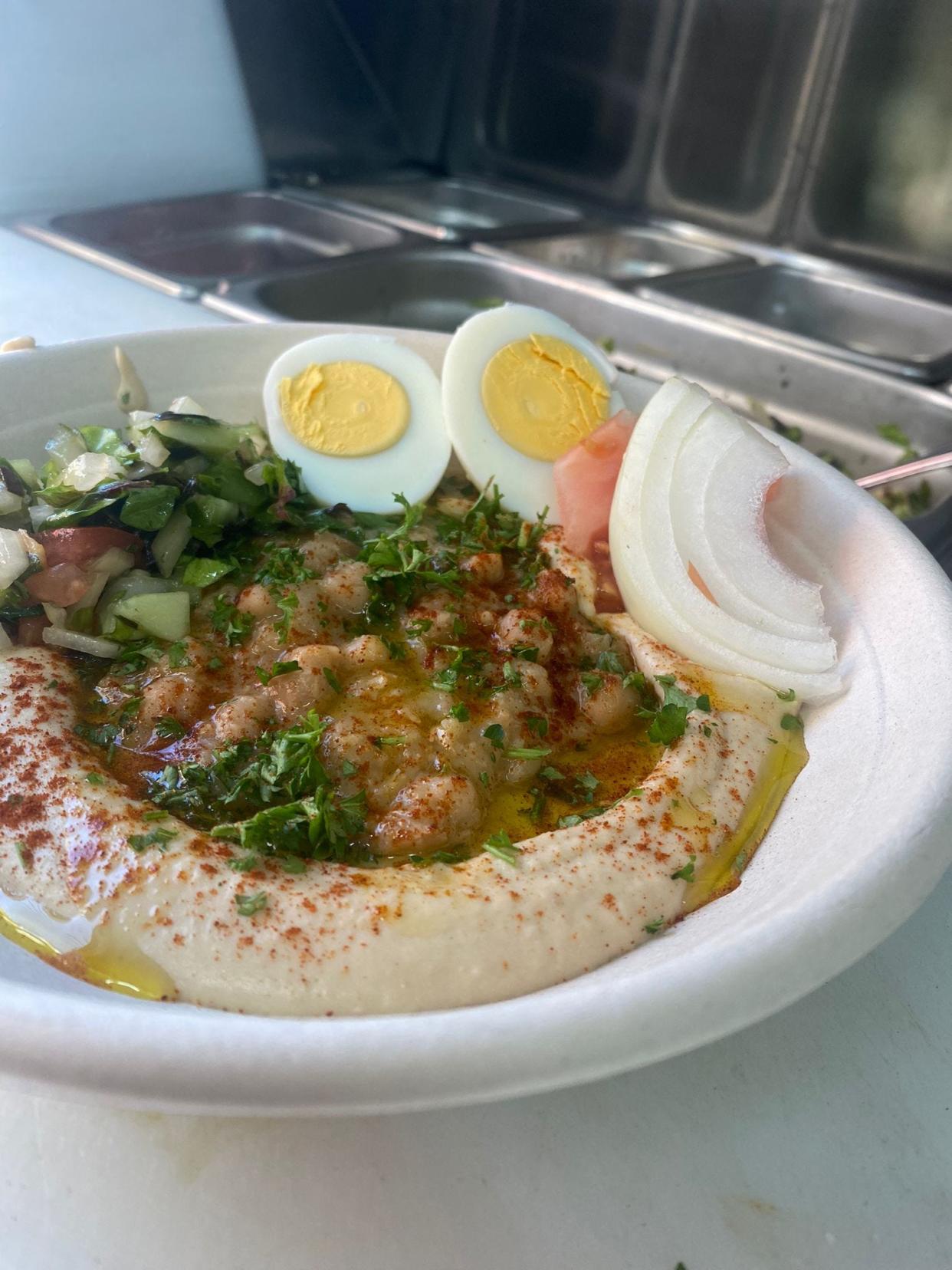 Yalla, a Middle Eastern cuisine food truck, offers Hummus Balagan made with eggplant, hard boiled egg, and chopped salad and served with a warm pita.