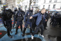 A demonstrator is pushed away by riot police officers during a banned protest in support of Palestinians in the Gaza Strip, in Paris, Saturday, May, 15, 2021. Marches in support of Palestinians in the Gaza Strip were being held Saturday in a dozen French cities, but the focus was on Paris, where riot police got ready as organizers said they would defy a ban on the protest. (AP Photo/Michel Euler)