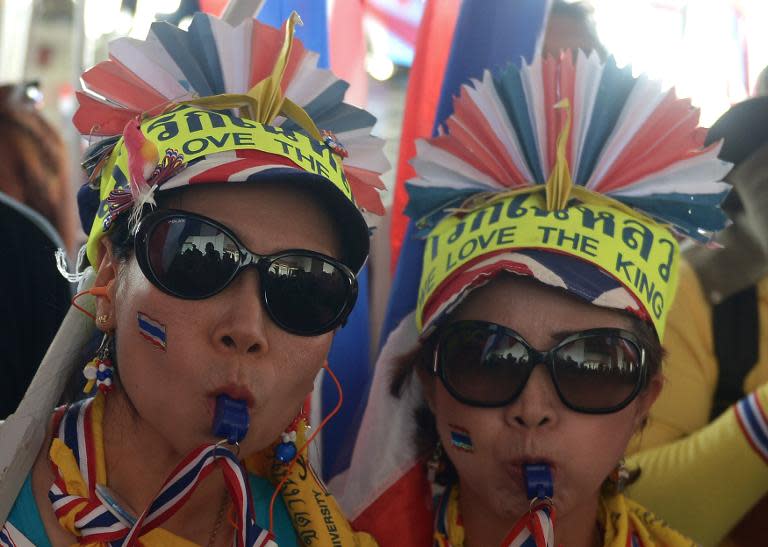 Thai anti-government protesters blow whistles during a rally at the Election Commission headquarters in Bangkok, on December 17, 2013