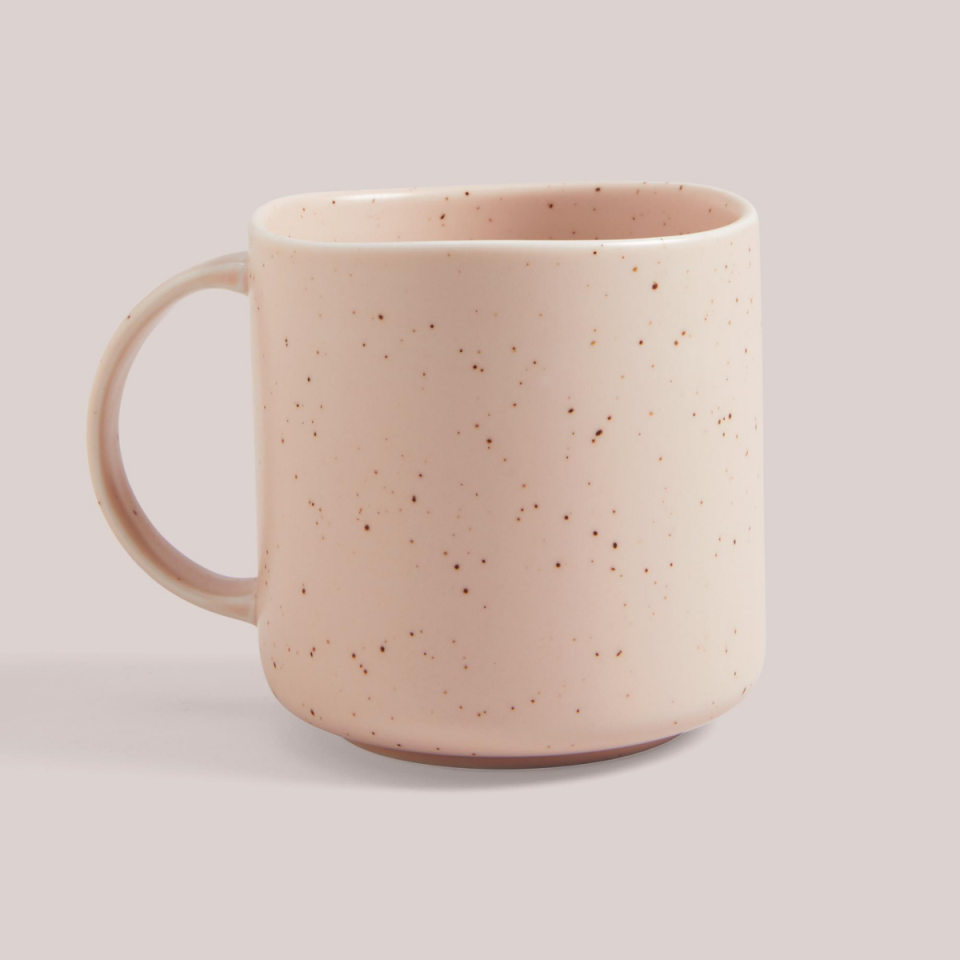 Hyde Mug, $4.95 from Country Road is shown in pink speckles against a pastel pink background. The ceramic has wavy edges on the lip of the mug.