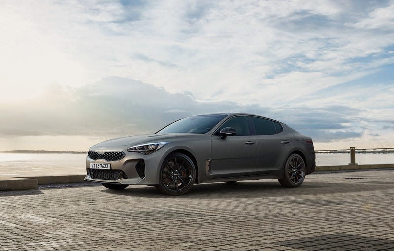 A grey Kia Stinger parked at the water's edge