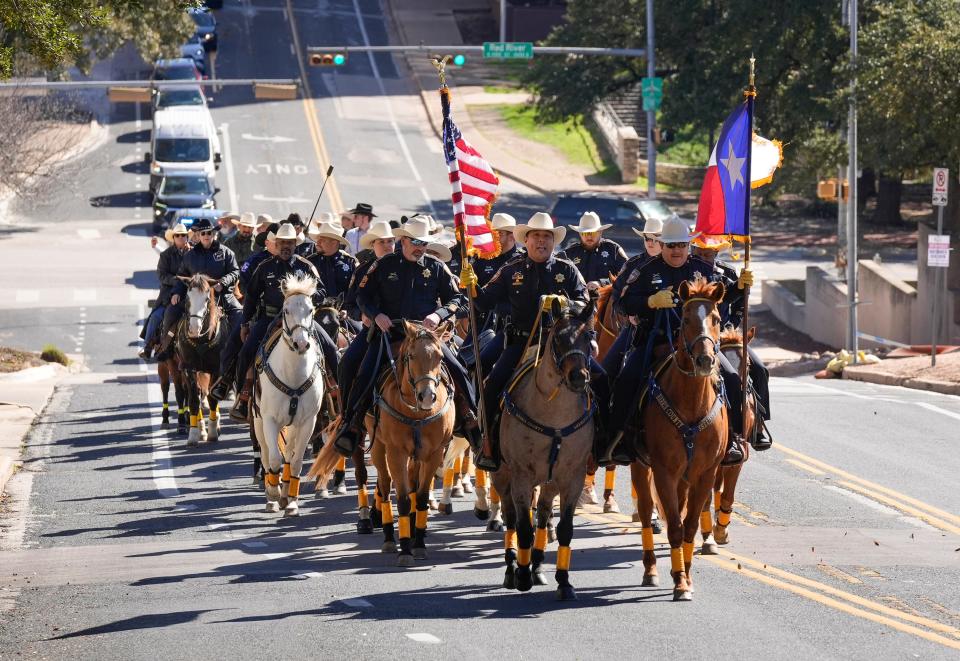 Mounted patrol officers from Houston-area law enforcement agencies ride on East 11th Street on their way to the Capitol during the 75th annual Pony Express on Monday Feb. 12, 2024. In a long-standing tradition, members of the Harris County sheriff’s office mounted patrol and others rode Pony-Express-style from NRG Park in Houston to the Capitol to personally deliver an invitation to Gov. Greg Abbott to attend the Houston Livestock Show & Rodeo, which will be Feb. 27 - March 17.