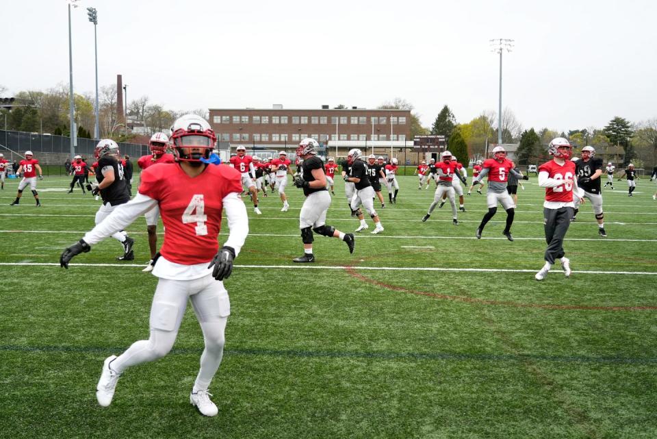 Defensive back Treyvon Hobbs, left, and his teammates limber up during Brown University's spring practice.