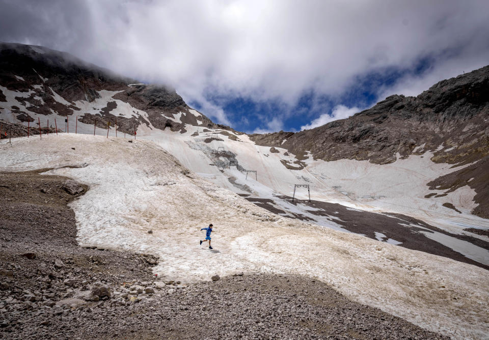 FILE - A youth runs over what remains of the glacier, that lost most of its volume during the last years, on top of the Zugspitze mountain near Garmisch-Partenkirchen, Saturday, June 25, 2022. Once the world had hope that when nations got together they could stop climate change. Thirty years after leaders around the globe first got together to try, that hope has melted. (AP Photo/Michael Probst, File)