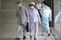 A man and a woman wearing face masks to help curb the spread of the coronavirus walk at an underpass Thursday, Aug. 27, 2020, in Tokyo. (AP Photo/Eugene Hoshiko)