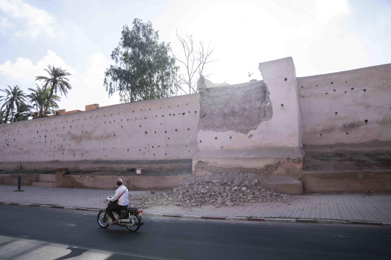 A man drives past a damaged wall of the historic Medina of Marrakech, after after an earthquake in Morocco, Saturday, Sept. 9, 2023. A rare, powerful earthquake struck Morocco late Friday night, killing more than 600 people and damaging buildings from villages in the Atlas Mountains to the historic city of Marrakech. (AP Photo/Mosa'ab Elshamy)
