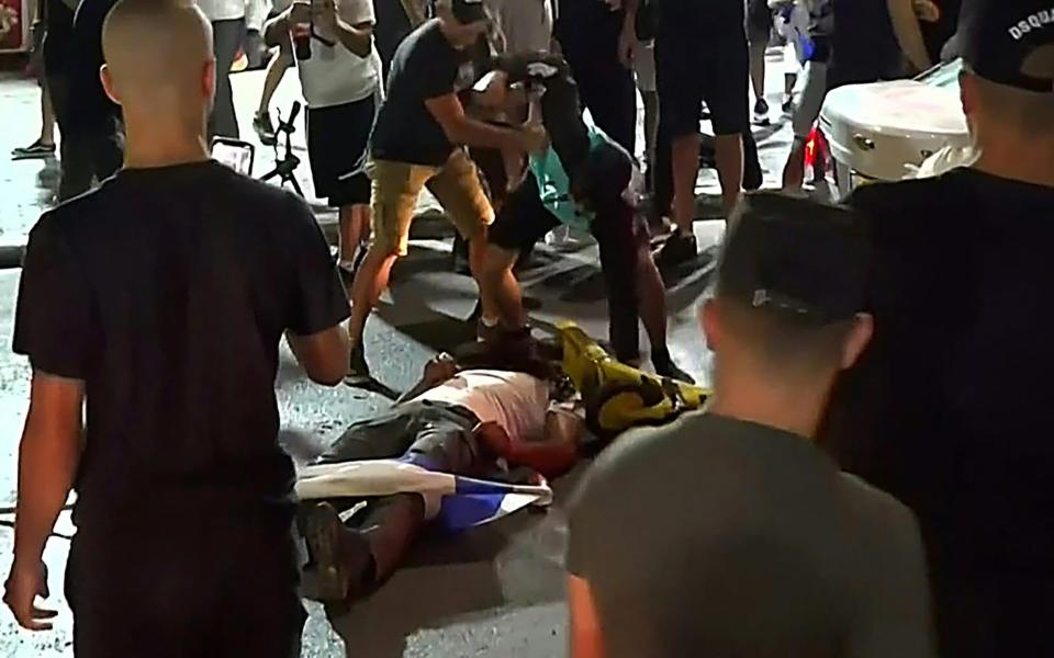 A far-Right Israeli mob attacking who they considered an Arab man, on the seafront promenade of Bat Yam - AFP