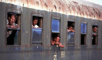 <p>Refugees from the camp in Kukes, Albania, wait on a train to leave the station in Shkoder, Albania for another camp in Durres in southern Albania, May 1999. The trains were decommissioned castoffs with windows edged with broken glass. Hundreds of thousands of Kosovo Albanians were driven from their homes into refugee camps in Macedonia and Albania in 1999 by the Serbian military. (Photo by Chris Hondros/Getty Images) </p>