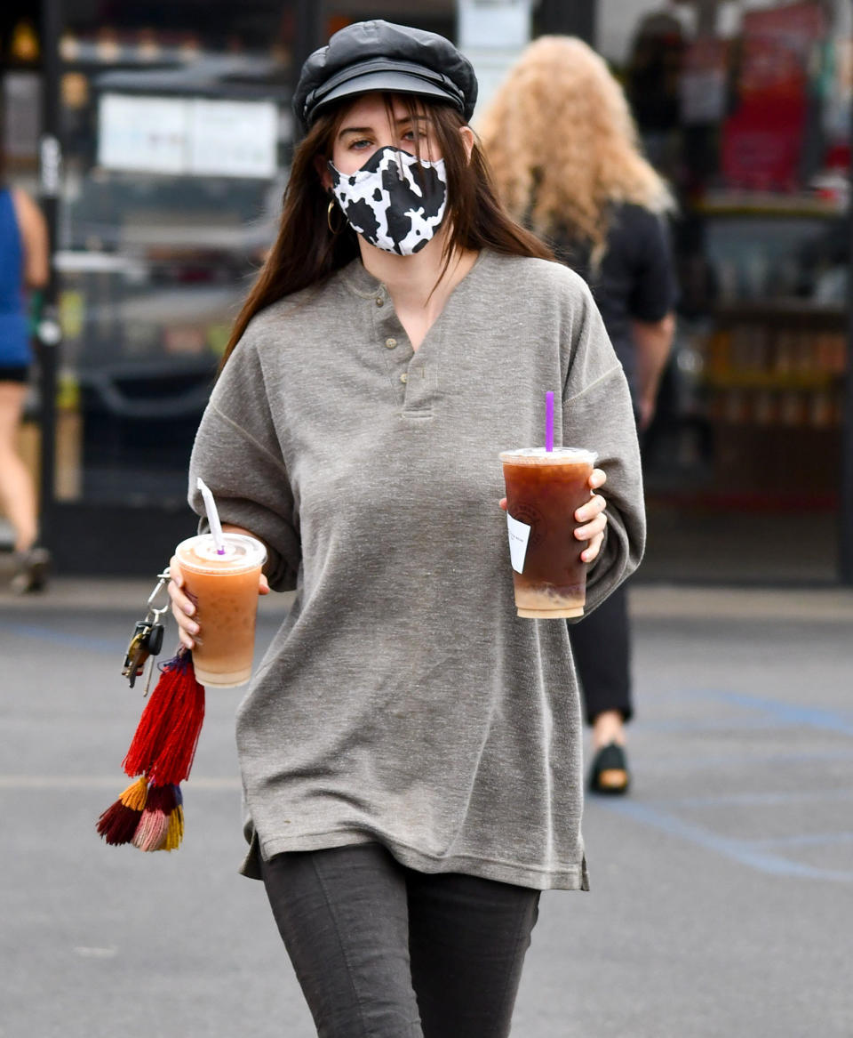 <p>Scout Willis wears a cow-print mask and grabs two drinks to go while out on Thursday in L.A.</p>