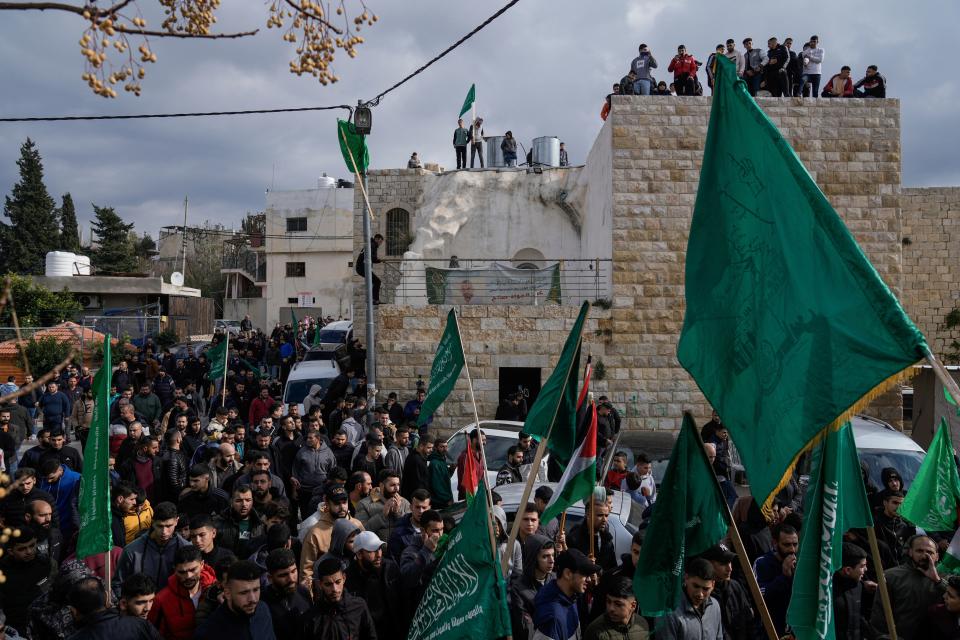 Palestinian demonstrators wave flags for Hamas and their national flags during a protest against the killing of top Hamas official Saleh Arouri in Beirut, in the West Bank town of Arura, on Friday, Jan. 5, 2024. Arouri, the No. 2 figure in Hamas, was killed in an explosion blamed on Israel. He is the highest-ranked Hamas figure to be killed in the nearly three-month war between Israel and Hamas