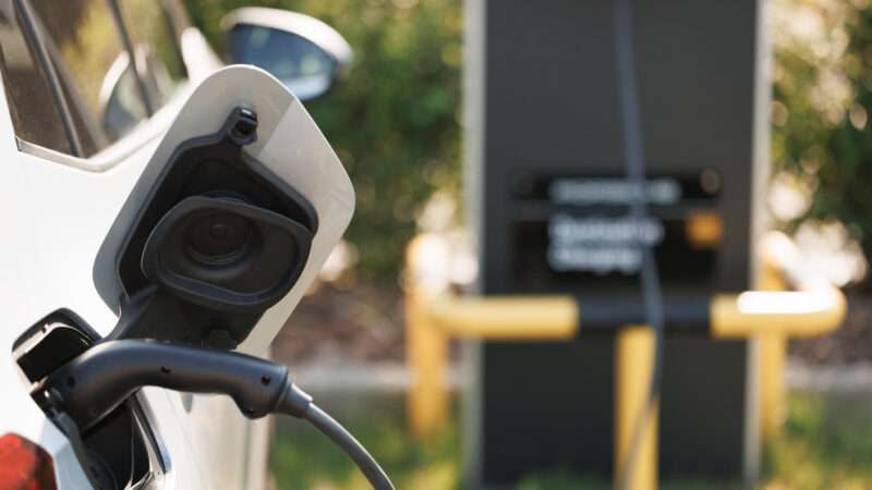 Close-up of an electric vehicle plugged in to charge.